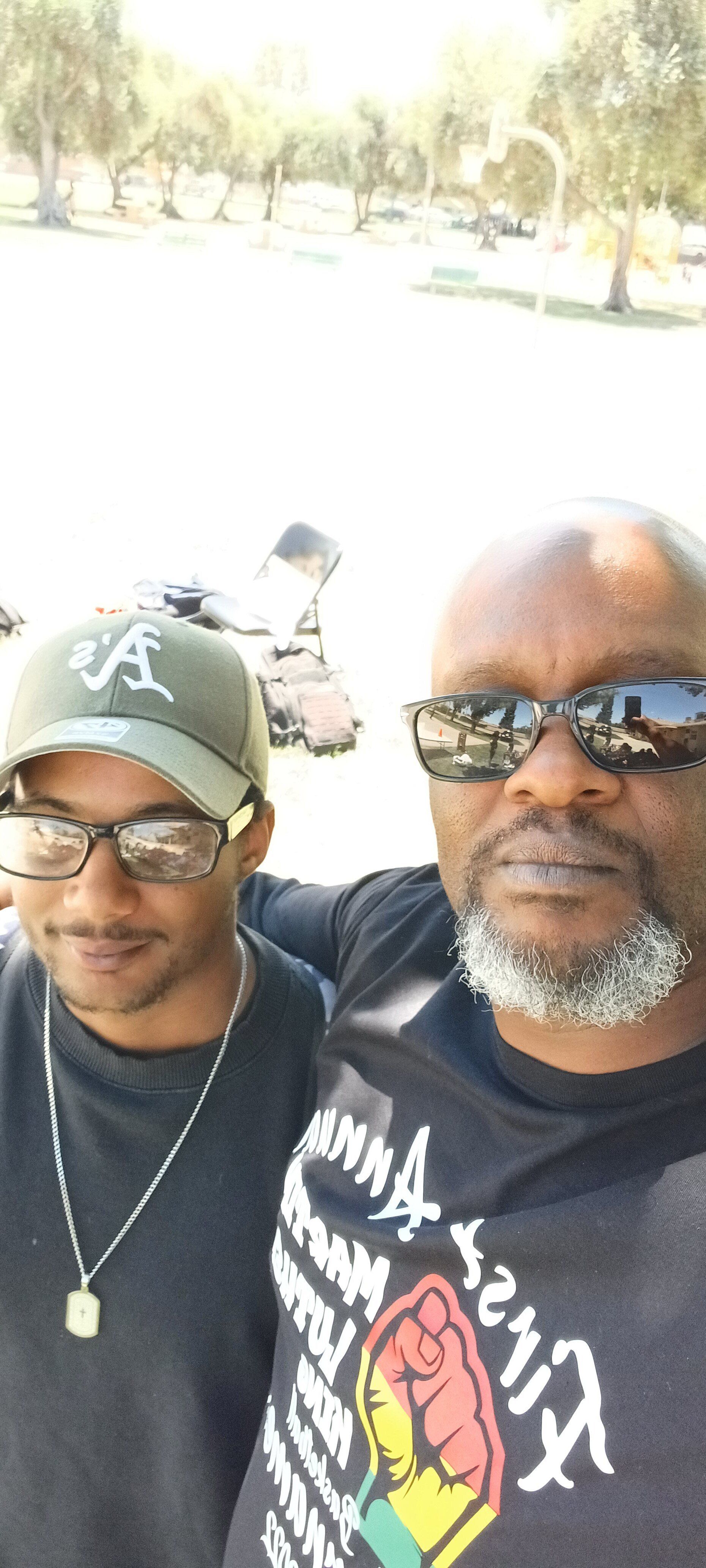 two men posing with trees on the background