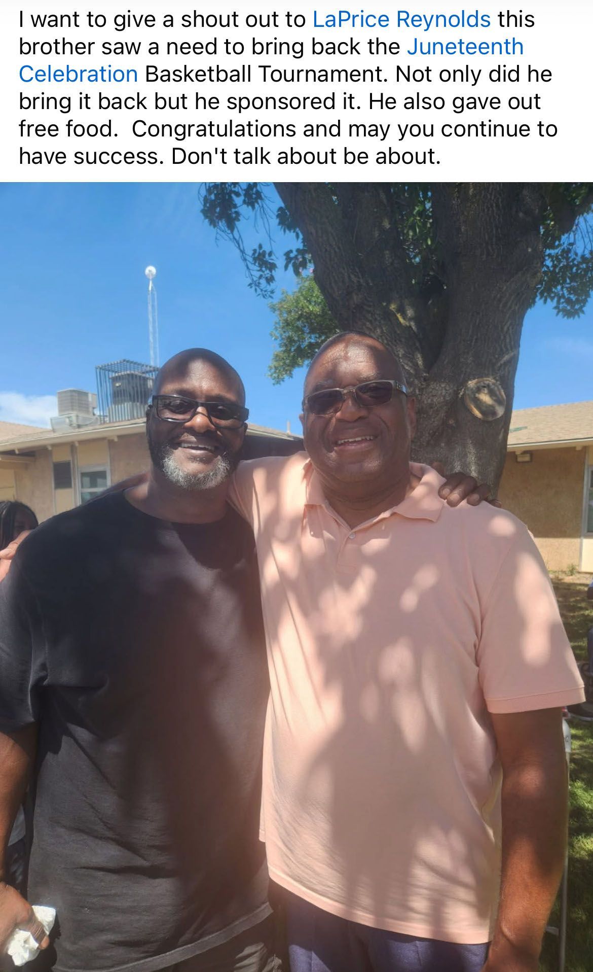 Two men are posing for a picture in front of a tree.