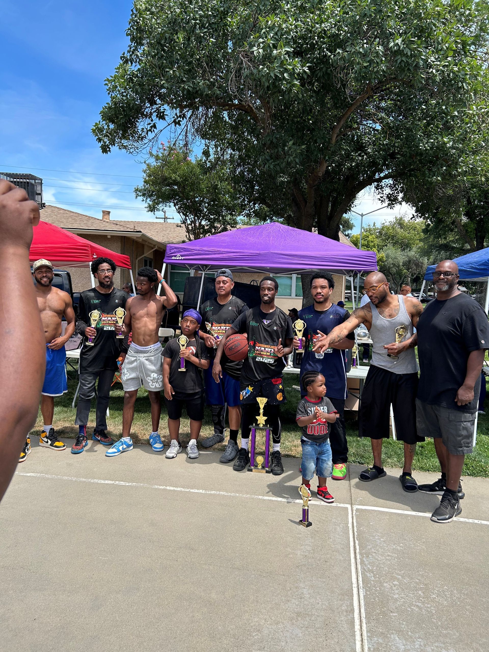 A group of people are posing for a picture on a basketball court.