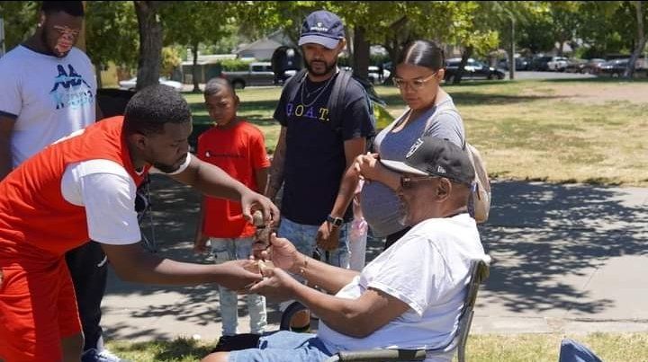 man giving basketball trophy to another man