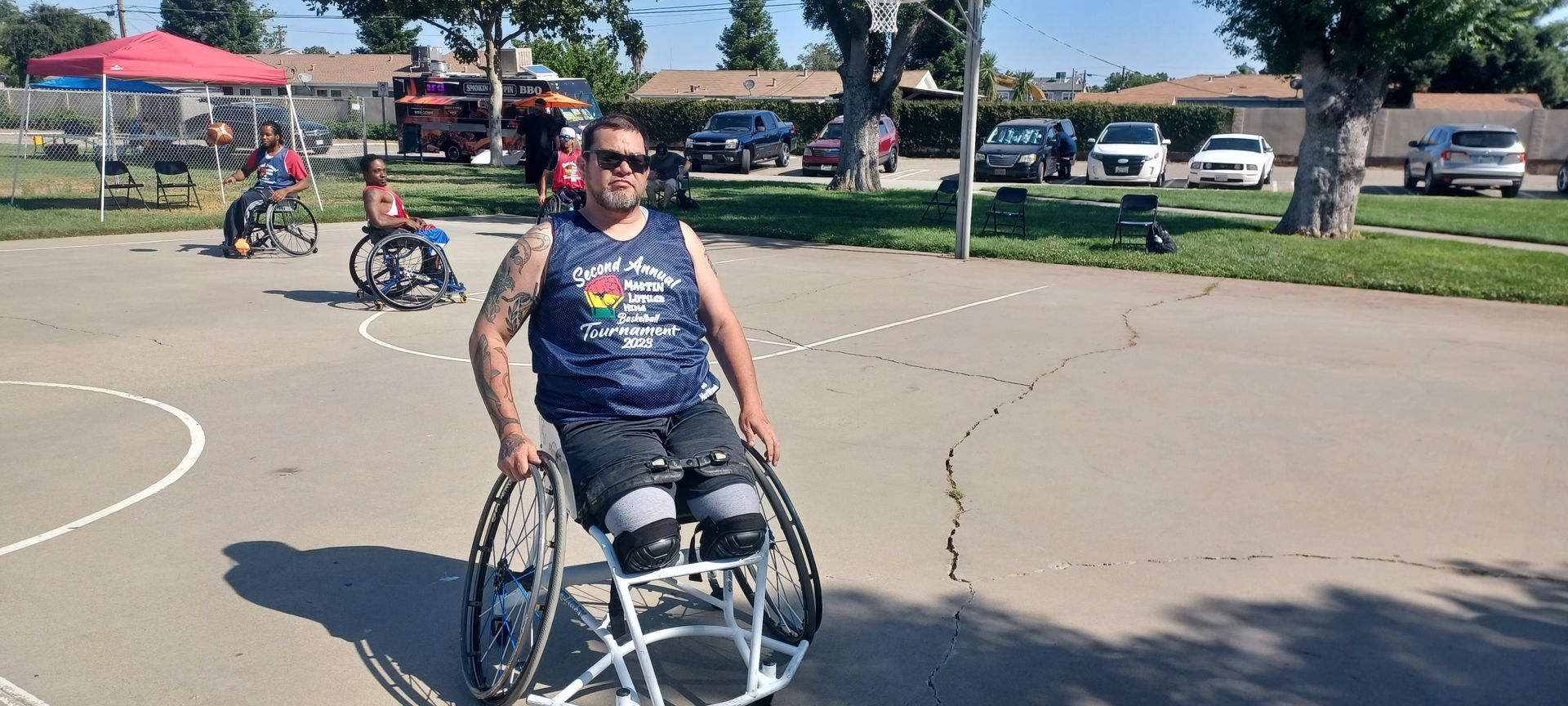 Man on a blue jersey sitting on a wheelchair