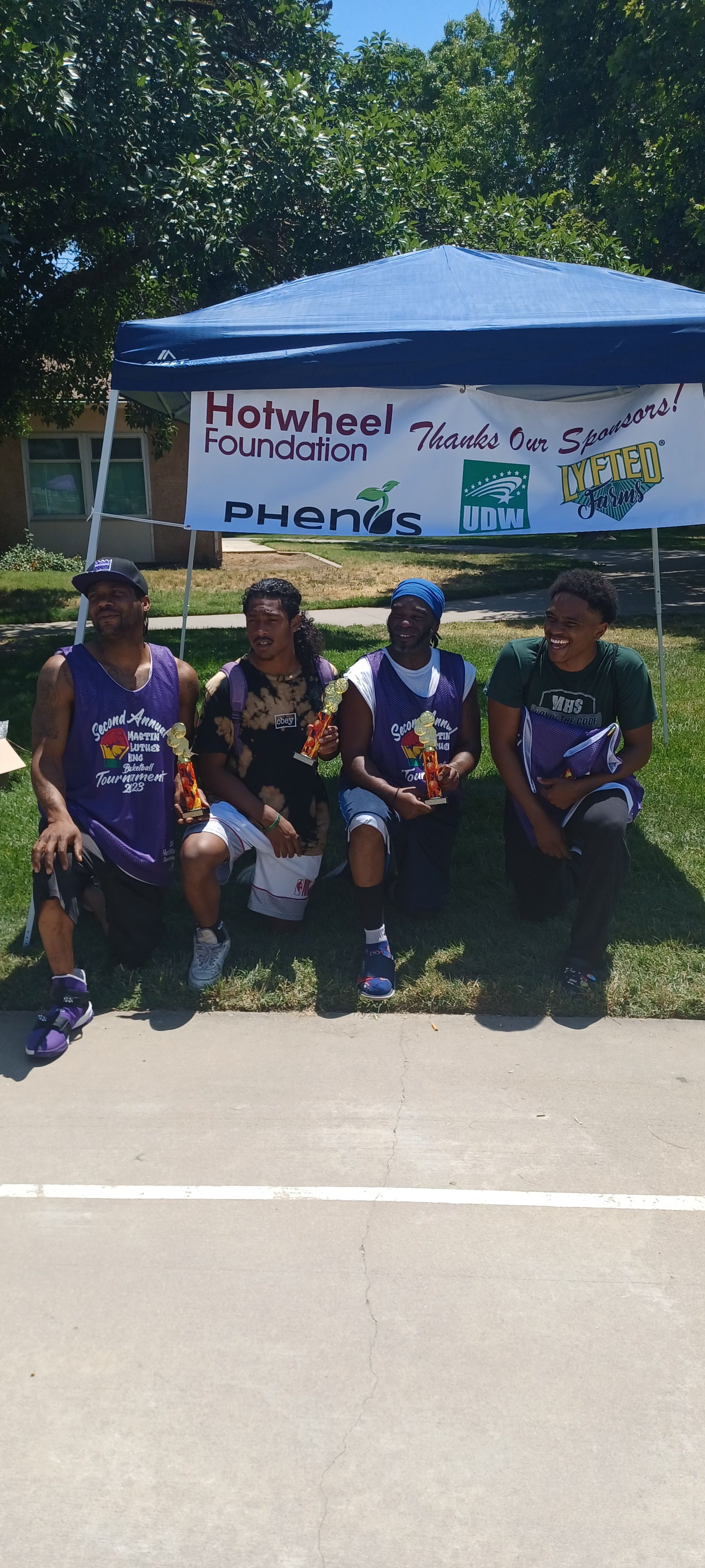 Four men sitting under the sun