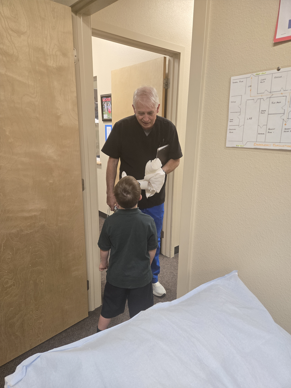 A man and a boy are standing next to each other in a room.