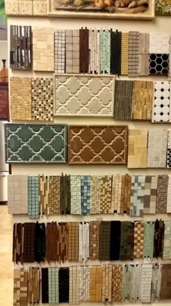 Tile samples displayed on a rack, featuring various colors, patterns, and textures.