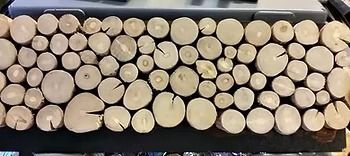 Close-up of wooden log slices, tightly arranged in a decorative pattern.