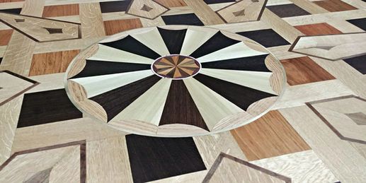 Ornate wooden floor with a circular centerpiece and geometric tile pattern.