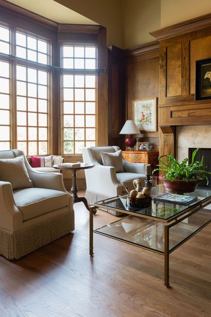 Living room with beige armchairs, bay window, fireplace, and glass coffee table.