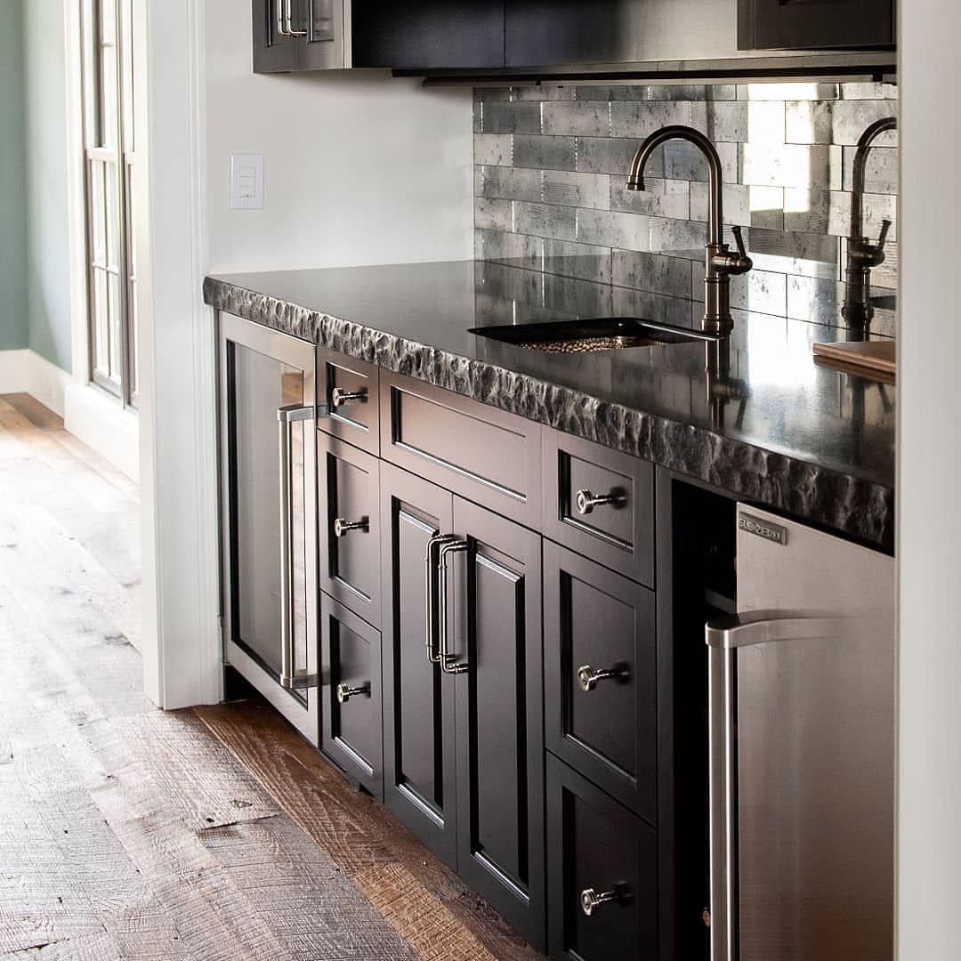 Dark gray wet bar with a black countertop and stainless steel appliances.