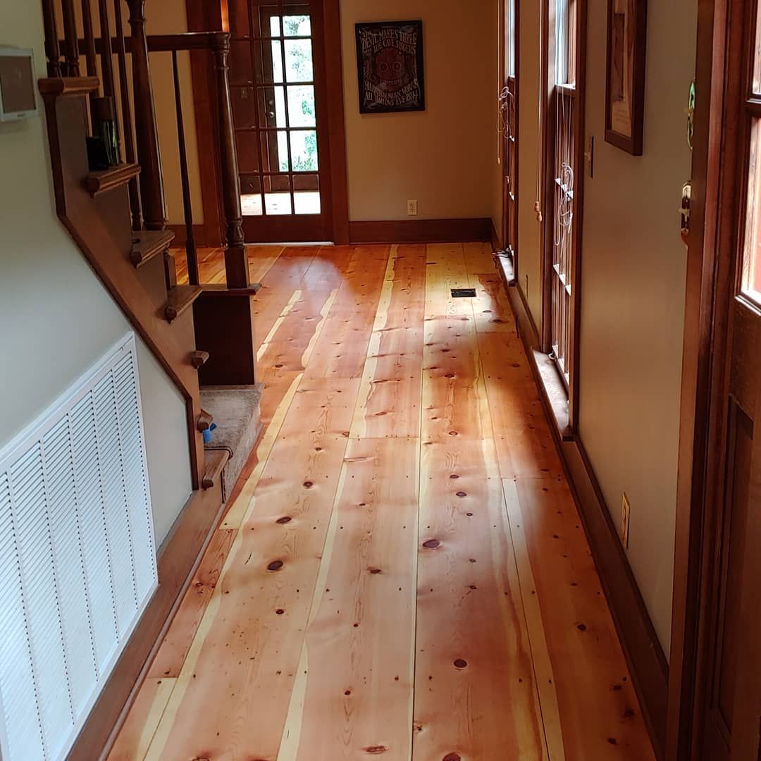 Wooden hallway with stairs on the left. Warm toned wood floor, trim, and staircase.