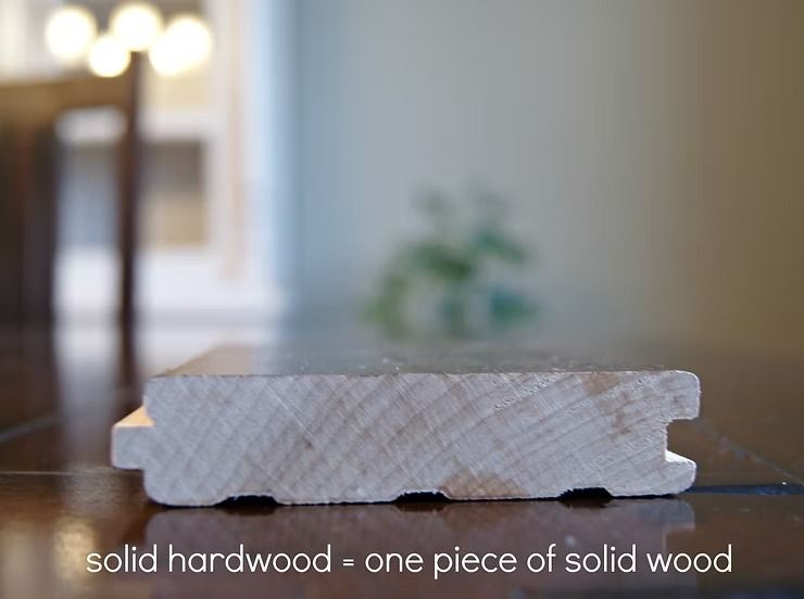 Cross-section of solid hardwood flooring, showing the wood grain and tongue-and-groove edges.