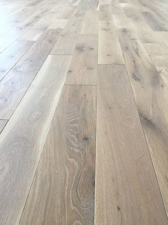 Light-colored wood floor planks arranged parallel, with grain visible and slight texture.