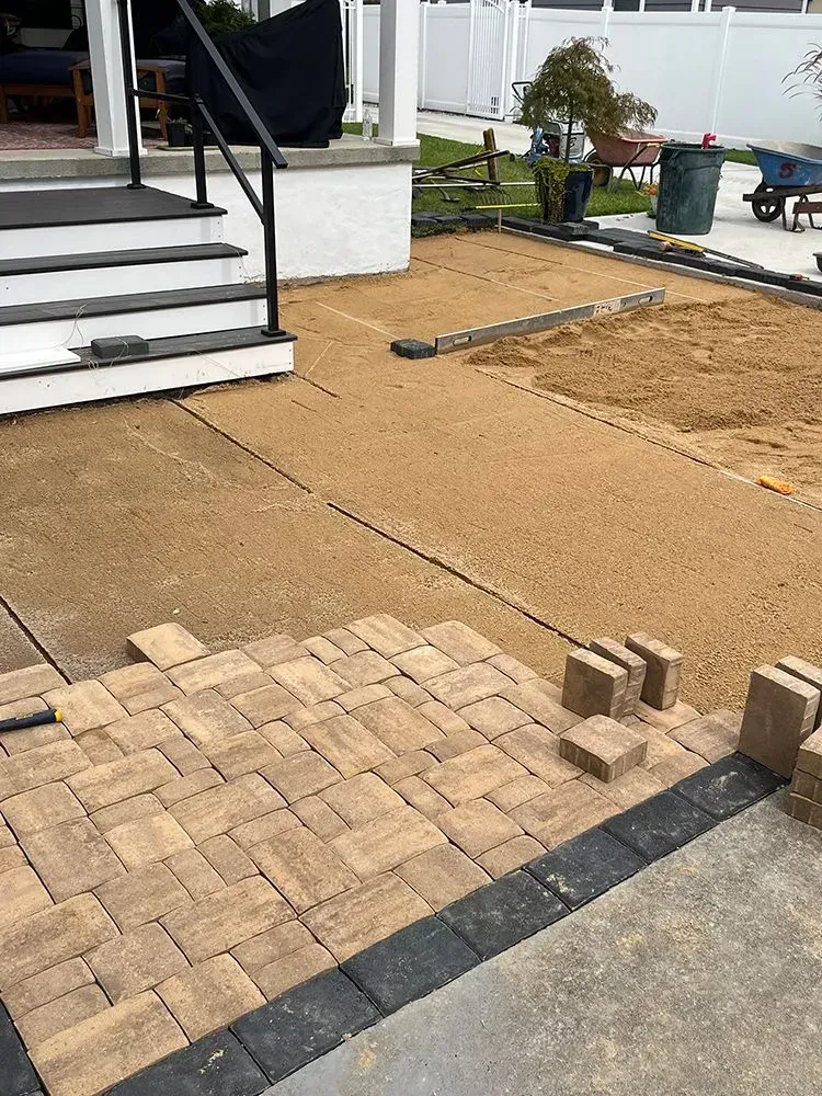 A brick walkway is being built in front of a house.