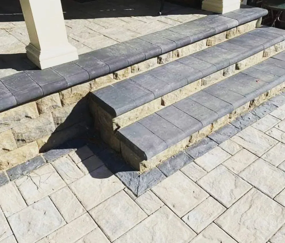 A set of stairs made of bricks on a sidewalk.