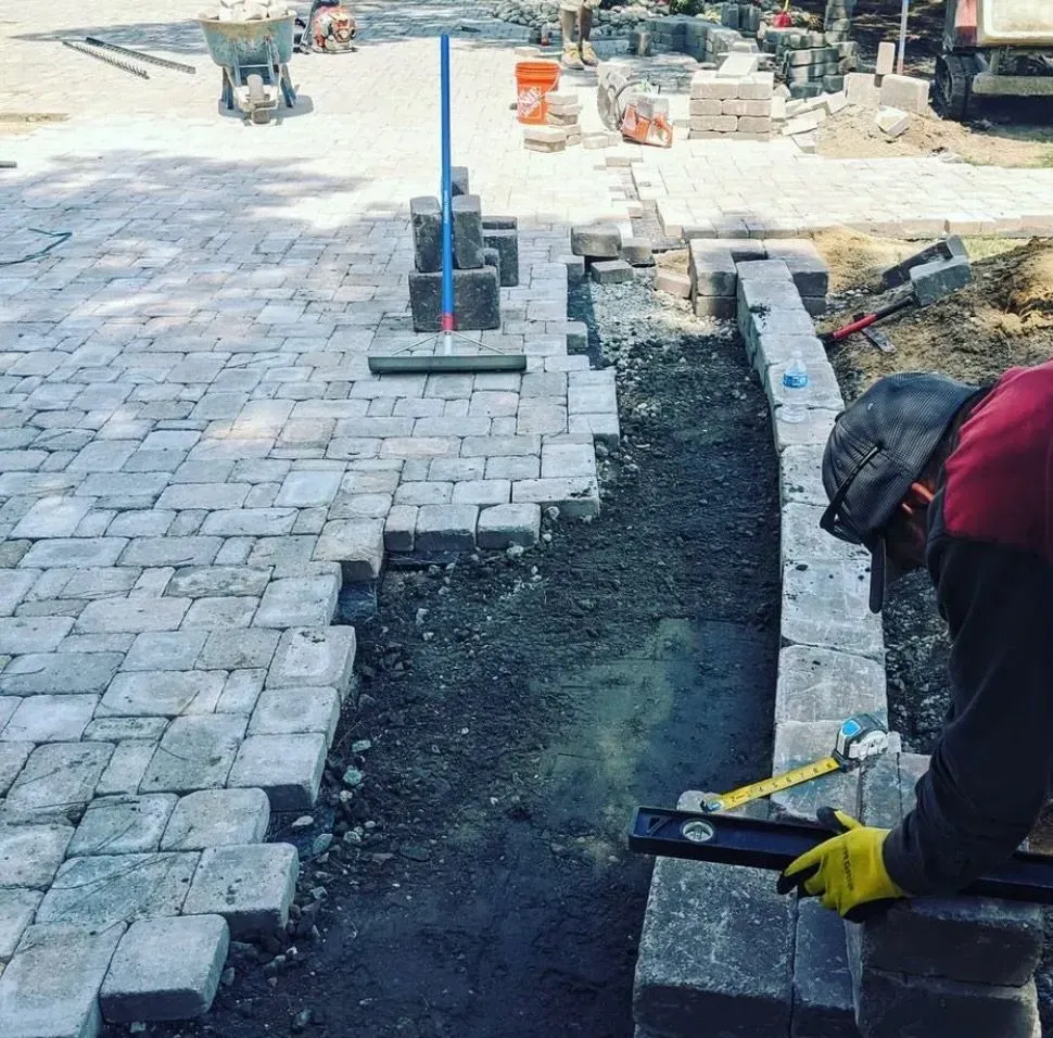 A construction worker is measuring a brick wall with a level.