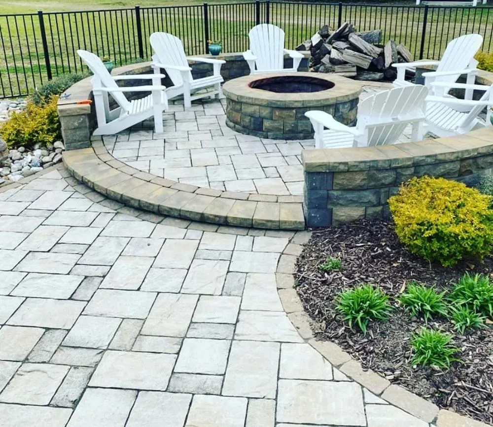 There is a fire pit in the middle of the patio surrounded by chairs.