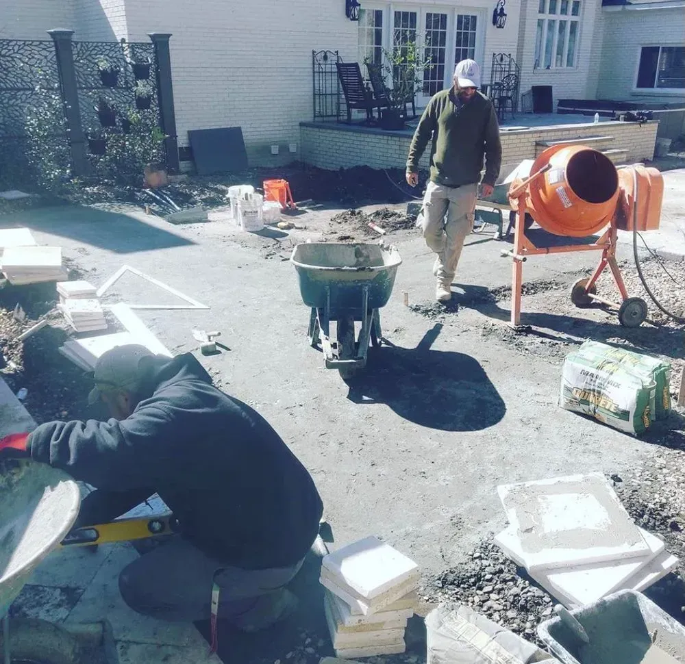 A man standing next to an orange cement mixer