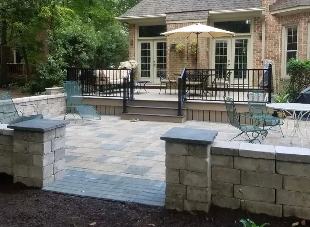 A patio with chairs and umbrellas in front of a house