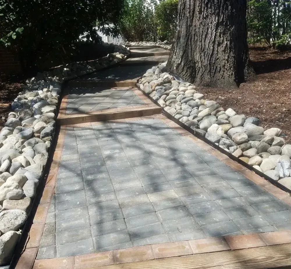 A stone walkway with a tree in the background