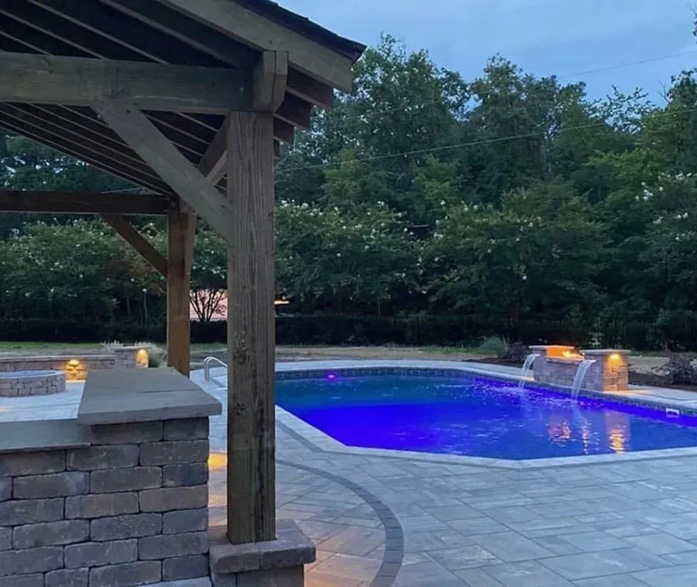 A large swimming pool is lit up with blue lights