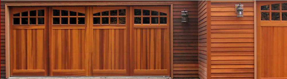 A wooden garage door is on the side of a house.