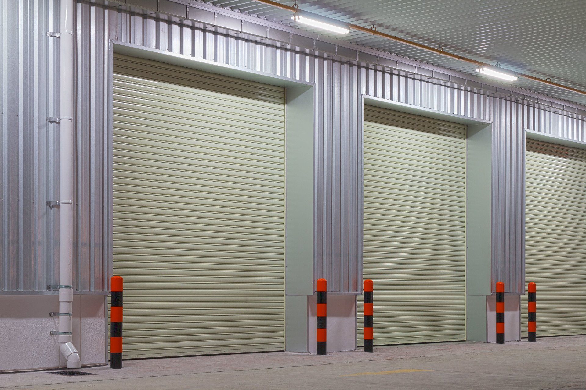 A row of roller shutter doors in a warehouse.