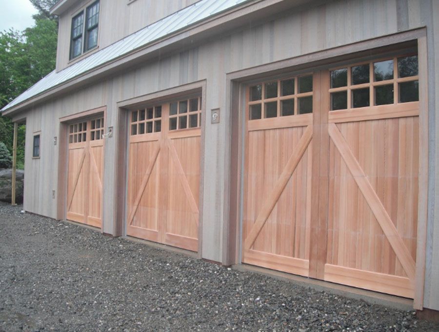 A row of wooden garage doors on the side of a house