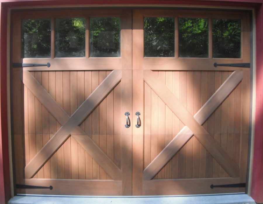 A wooden garage door with a red wall behind it