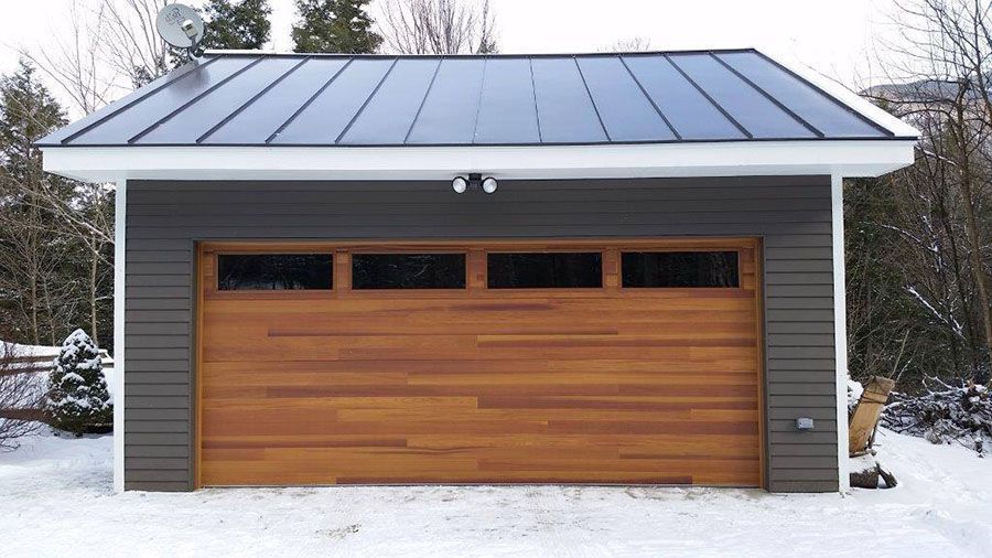 A garage with a wooden door and a solar panel on the roof