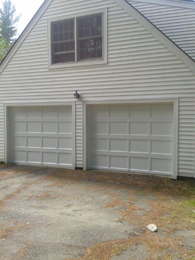 There are two garage doors on the side of a house
