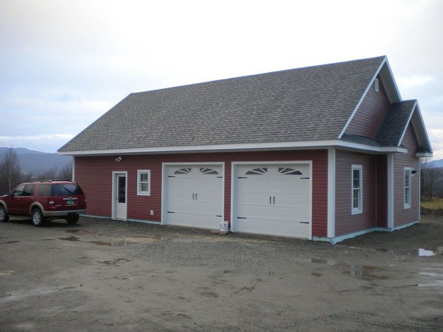 A red suv is parked in front of a garage