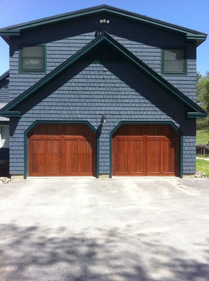 A blue house with two wooden garage doors
