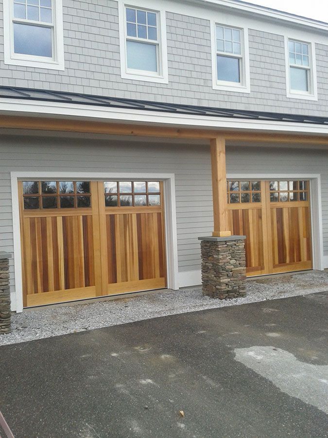 A house with a lot of windows and wooden garage doors