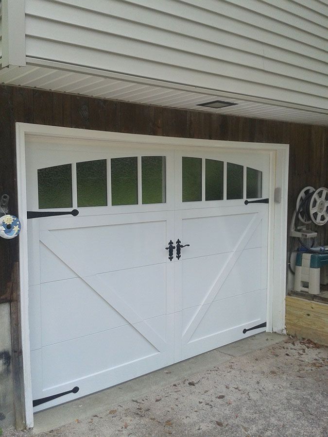 A white garage door with black handles and windows
