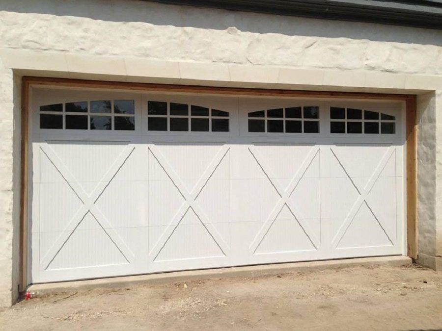 A white garage door with a cross design on it