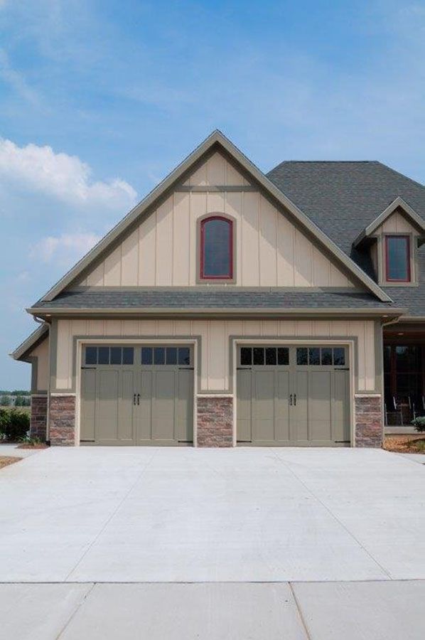 A house with two garage doors and a concrete driveway