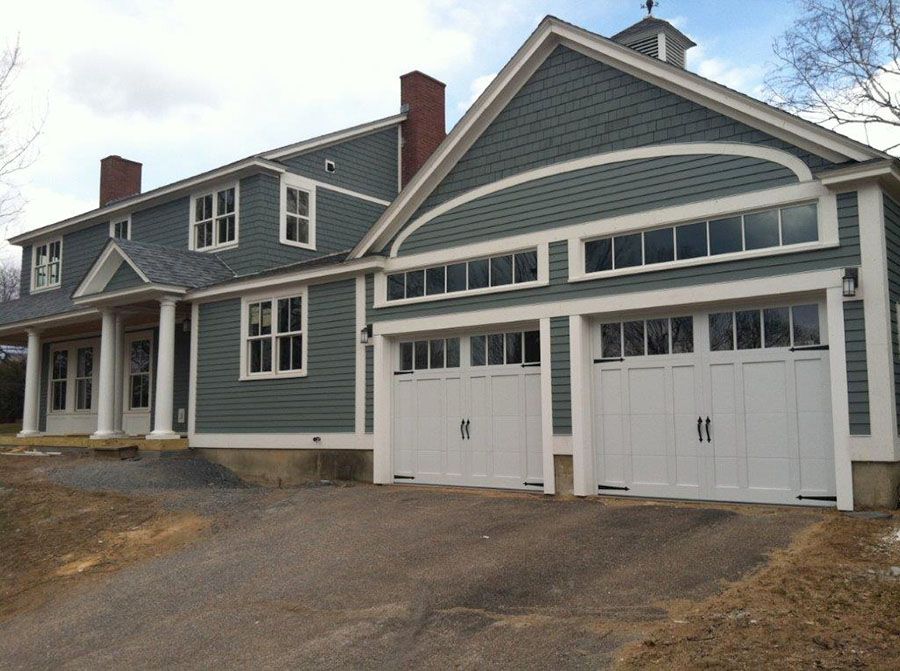 A large grey house with white garage doors