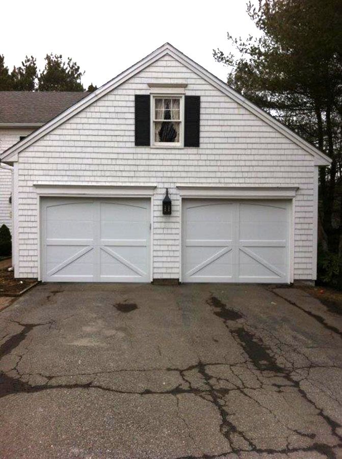 A white garage with black shutters and a window
