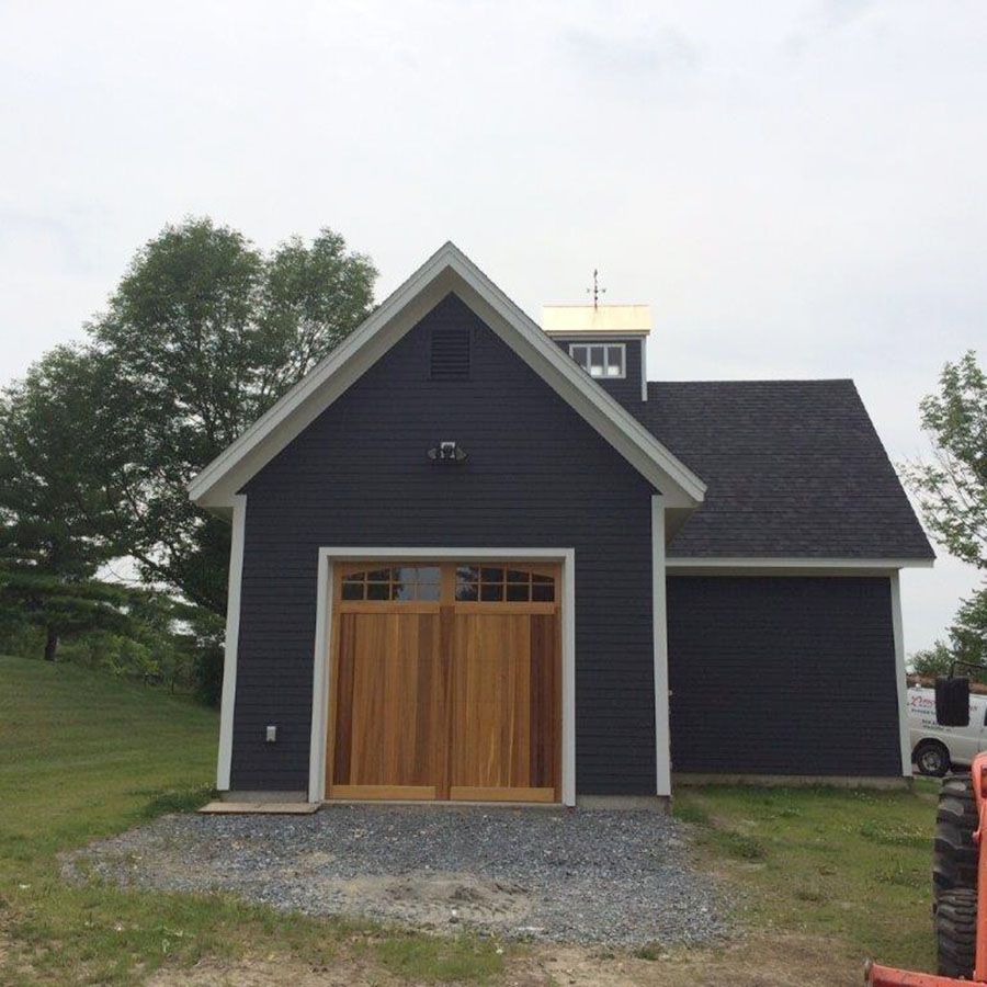 A black house with a wooden garage door