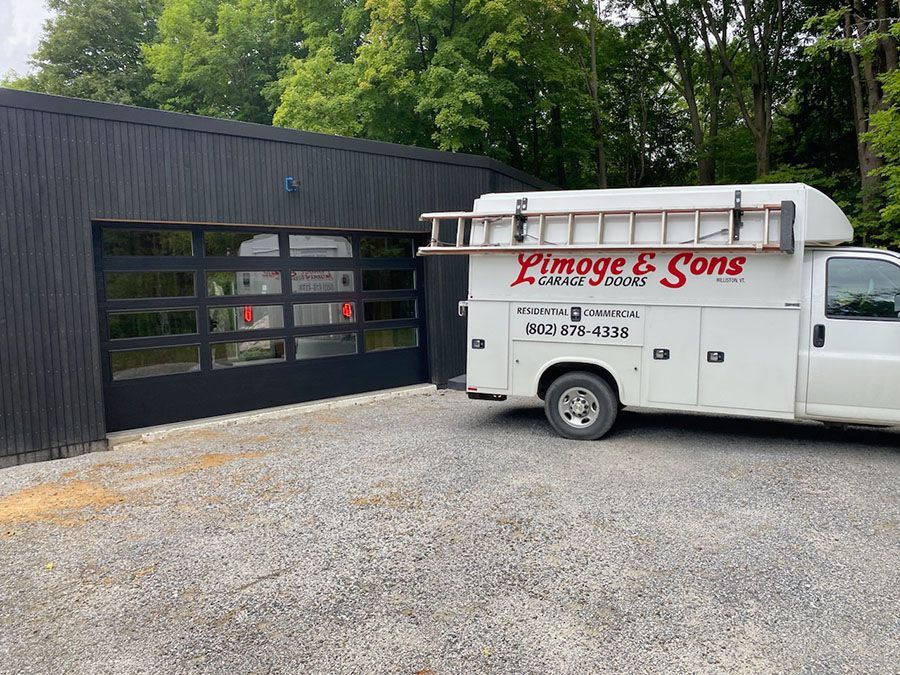 A white van is parked in front of a garage door