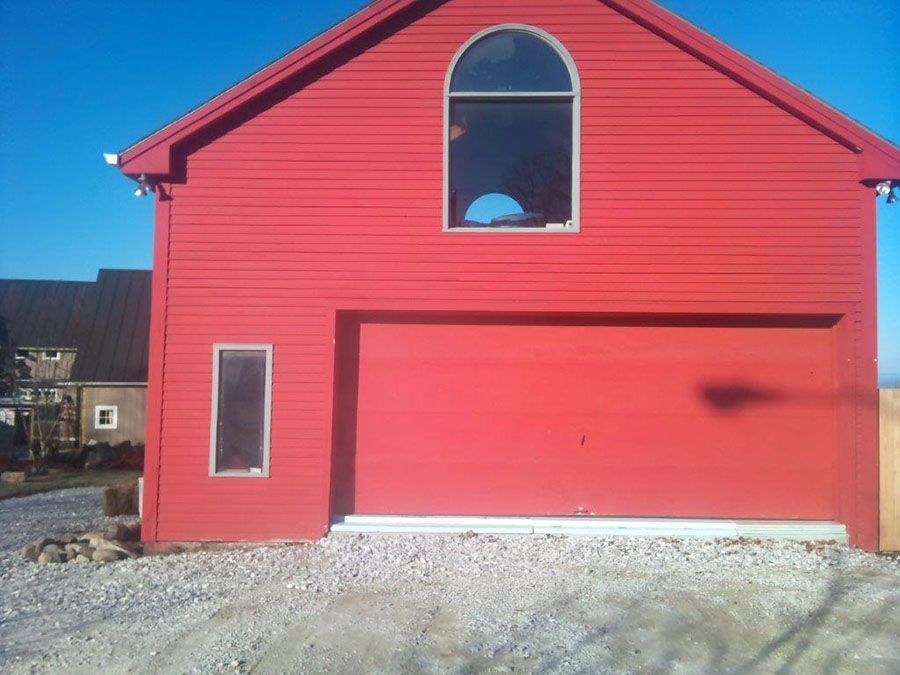 A red house with a garage door and a window