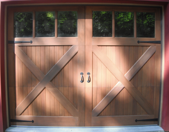 A wooden garage door with a red wall behind it