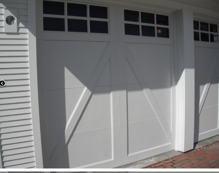 A white garage door with black windows and shutters