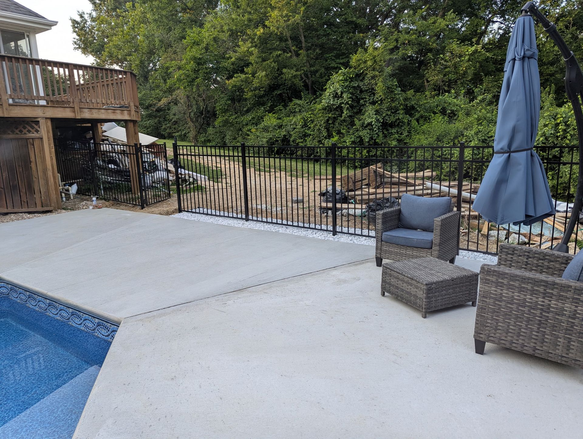 Black ornamental fence by a wooded area