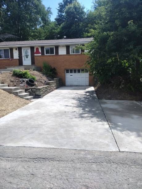 A driveway leading to a house with a garage door