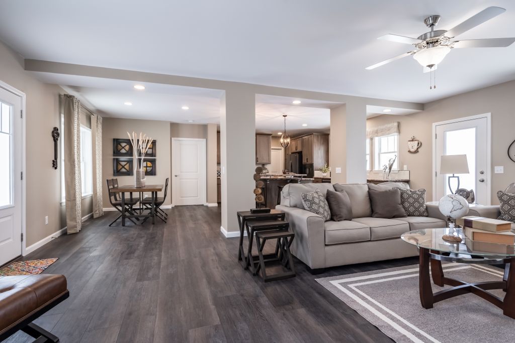 Living room with dark wood floors, light walls, and open to dining area and kitchen.