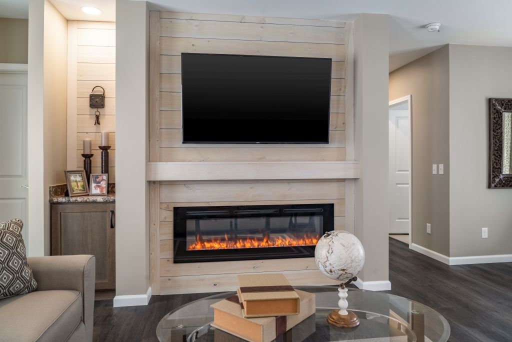 Living room with fireplace, TV, and globe; neutral tones, cozy atmosphere.