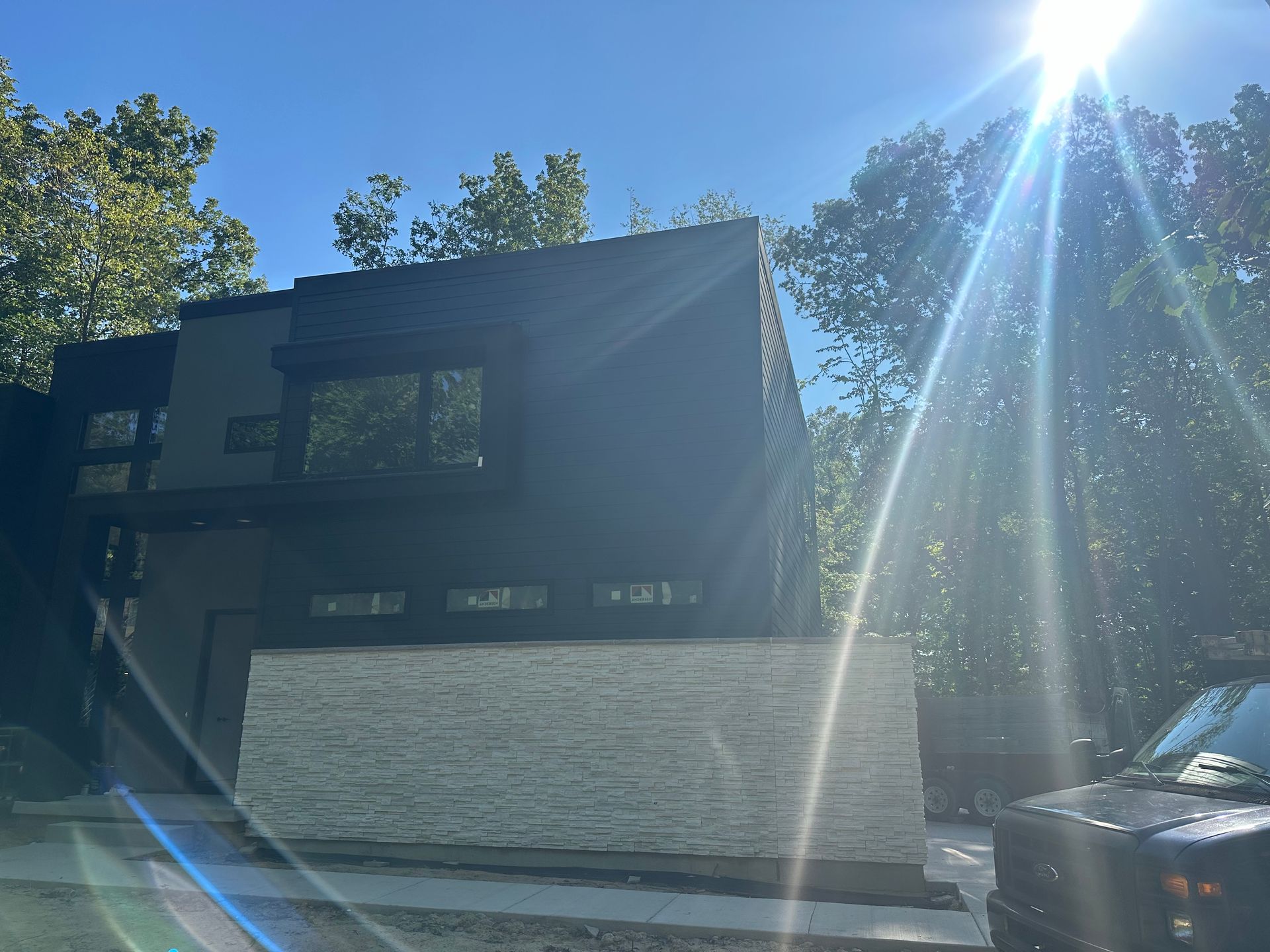 A black truck is parked in front of a black house