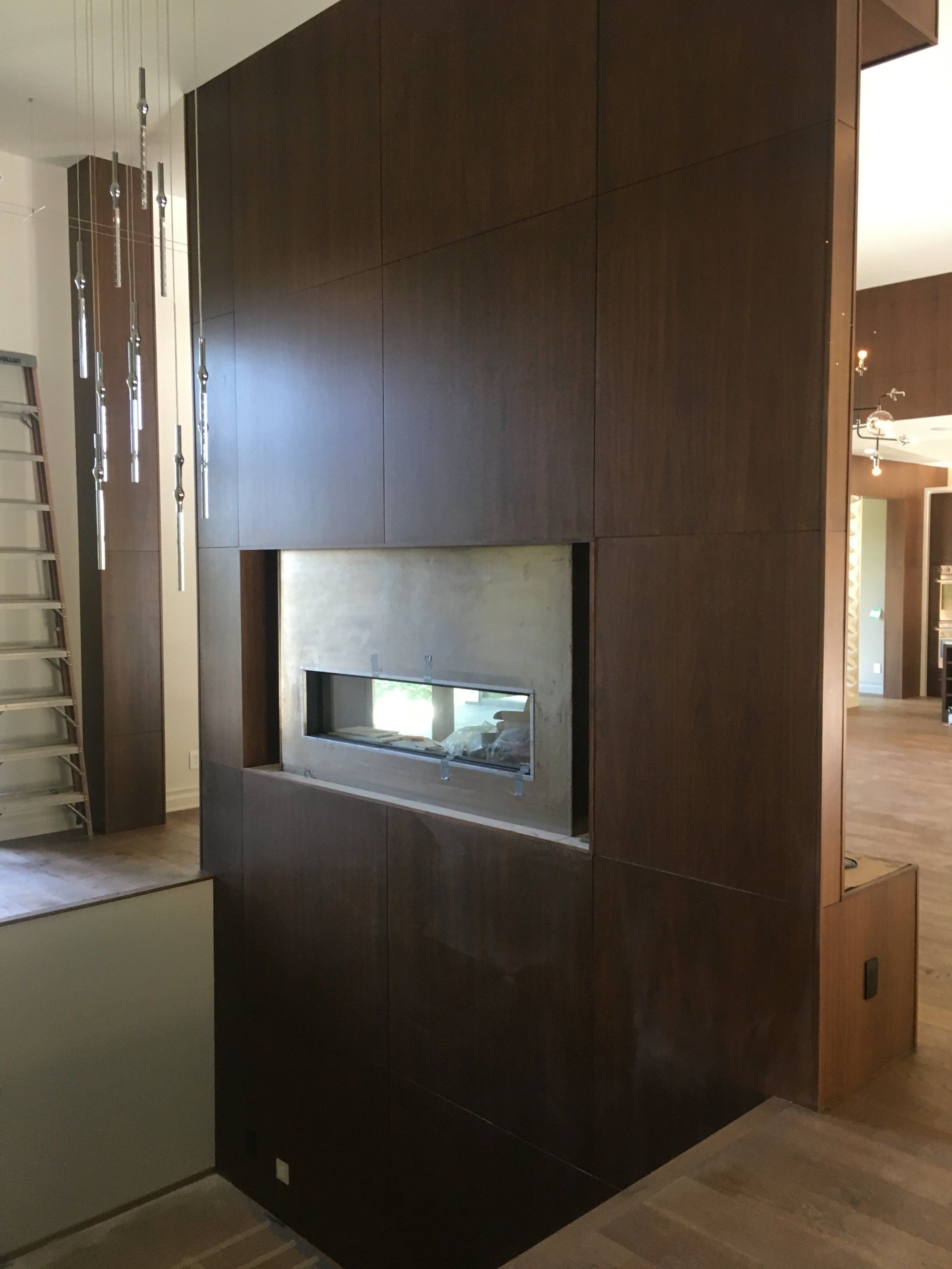 A wooden wall with a fireplace in the middle of it
