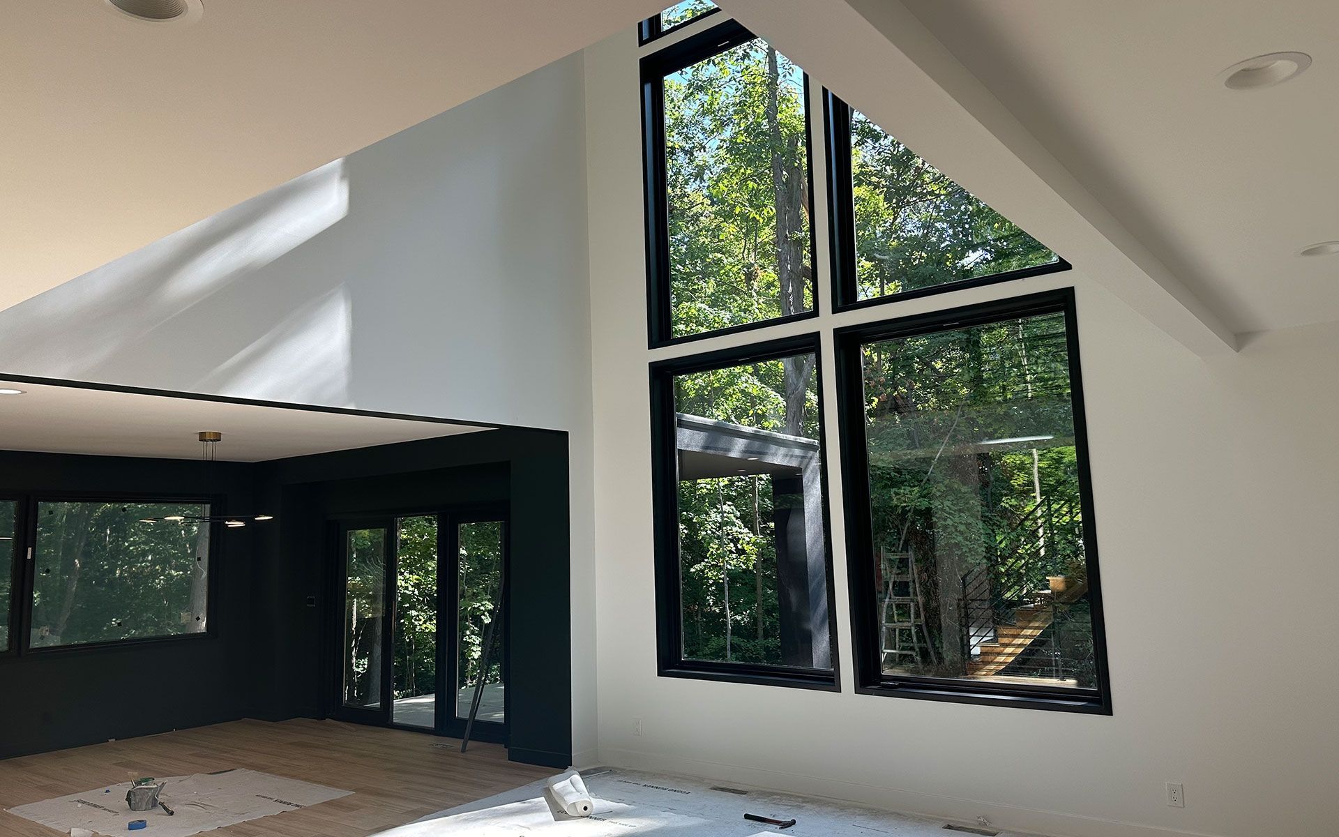 An empty room with a lot of windows and trees in the background.