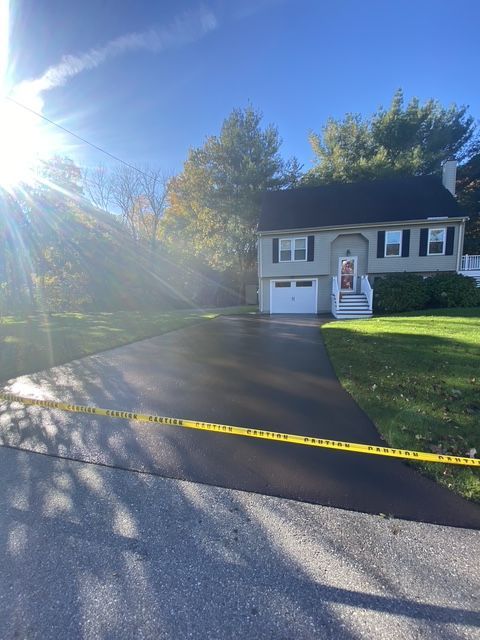 Suburban house with driveway, garage, and caution tape across the front lawn in bright sunlight